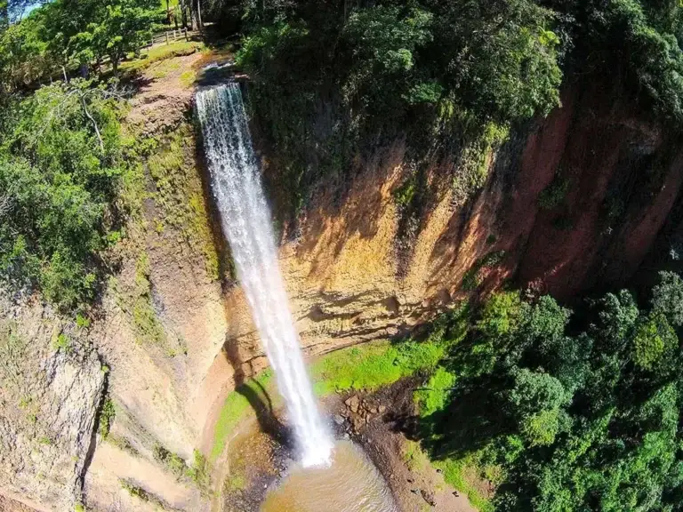 Cachoeira do Saltão, com uma queda d'água alta descendo por um paredão de pedra coberto de vegetação.