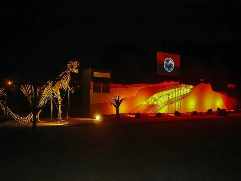 Fachada iluminada à noite do Planetário CEU, em Brotas, com céu escuro.